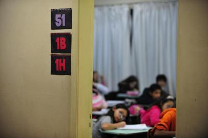  Dominical sobre escolas públicas que se esforçam para conseguir recursos para se manter. Na foto, estagiário de psicologia conversa com alunos.