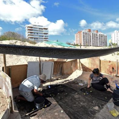 Archaeologists work at the archaeological site where indigenous bones and stones remains have been found, at the Playa Mansa in Punta del Este, Maldonado, on April 16, 2018.The Uruguayan resort of Punta del Este, very well known for its VIP visitors and the glamour of its sunny summers, is now house to an archaeological site with traces of indigenous people who inhabited the area before the arrival of the Spanish. / AFP PHOTO / MIGUEL ROJO / TO GO WITH AFP STORY by MAURICIO RABUFFETTI