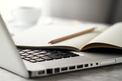 Closeup of Workspace with Modern Creative Laptop, Cup of Coffee and Pencils. Horizontal with Copy Space. 