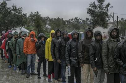 ISLAND-MAGRA-ART-NSPR-040318Refugees, mostly from Cameroon and Congo, queue up to receive breakfast, reportedly only a bottle of water and a croissant, at the makeshift camp outside Moria, on the Greek island of Lesbos, Feb. 27, 2018. Two years after the European Union and Turkey struck a deal to cut off asylum seekers crossing the Aegean, thousands languish in deplorable conditions on Lesbos. (Mauricio Lima/The New York Times)Editoria: ILocal: LESBOS ISLANDIndexador: MAURICIO LIMAFonte: NYTNSFotógrafo: STR