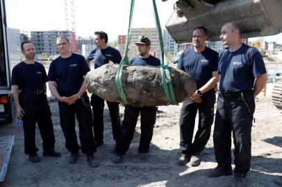  German policemen pose next to a bomb dropped during World War II during the disposal operation on April 20, 2018 in Berlin.Thousands of people around Berlins central railway station were evacuated as bomb disposal experts defused an unexploded World War II explosive unearthed on a building site in Berlins Mitte district. / AFP PHOTO / Odd ANDERSENEditoria: WARLocal: BerlinIndexador: ODD ANDERSENSecao: human scienceFonte: AFPFotógrafo: STF