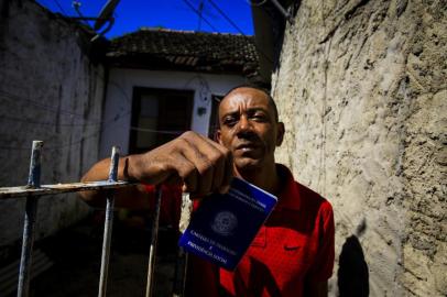  PORTO ALEGRE, RS, BRASIL, 17-04-2018: Paulo Roberto Pedroso Ribeiro com a carteira de trabalho dele em frente de casa, no bairro Restinga. Ele está desempregado e precisa ir ao Sine no Centro porque o serviço encerrou as atividades no bairro. Diversos serviços públicos oferecidos na Restinga deixaram de funcionar nos últimos 15 meses. (Foto: Mateus Bruxel / Agência RBS)