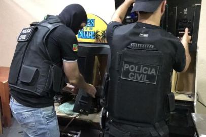 Policiais civis realizaram, na manhã desta sexta-feira (27), uma operação para descapitalizar organização criminosa que explorava jogos de azar e depois lavava dinheiro com imóveis, lojas e veículos no Rio Grande do Sul. Foram cumpridos 32 mandados de busca e apreensão em Porto Alegre, Cachoeirinha, Canoas e Xangri-lá. Além disso, mais de 60 veículos e imóveis foram sequestrados judicialmente. O grupo adquiriu um patrimônio superior a R$ 15 milhões com as atividades ilícitas. Durante o cumprimento dos mandados de busca, os agentes apreenderam armas e localizaram em Canoas um depósito com 200 máquinas caça-níqueis. Três pessoas foram detidas por posse ilegal de arma de fogo. 