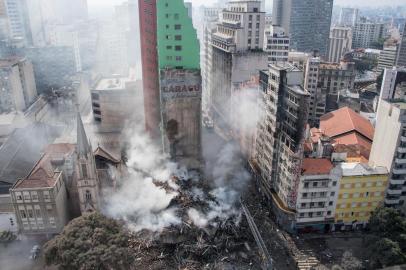  Firefighters work to extinguish the fire in a building that collapsed after catching fire in Sao Paulo, Brazil, on May 1, 2018.A 24-storey building in the center of Sao Paulo, Brazil's biggest city, collapsed early May 1 after a blaze that rapidly tore through the structure, reportedly killing one person. Dozens of homeless families were squatting in the building, according to local media. / AFP PHOTO / Nelson ALMEIDAEditoria: DISLocal: Sao PauloIndexador: NELSON ALMEIDASecao: fireFonte: AFPFotógrafo: STF