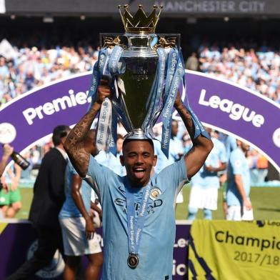 Manchester Citys Brazilian striker Gabriel Jesus holds the Premier League trophy on the pitch after the English Premier League football match between Manchester City and Huddersfield Town at the Etihad Stadium in Manchester, north west England, on May 6, 2018. / AFP PHOTO / Oli SCARFF / RESTRICTED TO EDITORIAL USE. No use with unauthorized audio, video, data, fixture lists, club/league logos or live services. Online in-match use limited to 75 images, no video emulation. No use in betting, games or single club/league/player publications.  / 