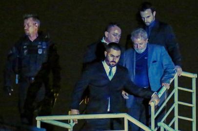  Brazilian ex-president (2003-2011) Luiz Inacio Lula da Silva (C) arrives at the Federal Police headquarters where he is due to serve his 12-year prison sentence, in Curitiba, Parana State, Brazil, on April 7, 2018.Brazils election frontrunner and controversial leftist icon said Saturday that he will comply with an arrest warrant to start a 12-year sentence for corruption. I will comply with their warrant, he told a crowd of supporters. / AFP PHOTO / Heuler AndreyEditoria: POLLocal: CuritibaIndexador: HEULER ANDREYSecao: electionFonte: AFPFotógrafo: STR