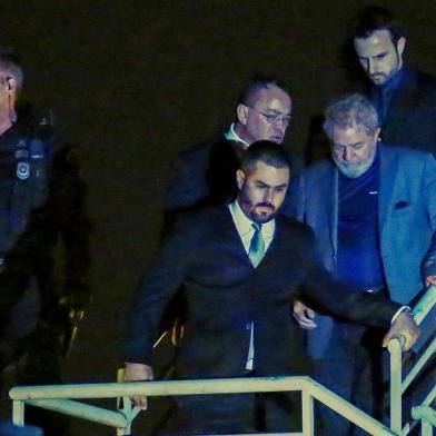  Brazilian ex-president (2003-2011) Luiz Inacio Lula da Silva (C) arrives at the Federal Police headquarters where he is due to serve his 12-year prison sentence, in Curitiba, Parana State, Brazil, on April 7, 2018.Brazils election frontrunner and controversial leftist icon said Saturday that he will comply with an arrest warrant to start a 12-year sentence for corruption. I will comply with their warrant, he told a crowd of supporters. / AFP PHOTO / Heuler AndreyEditoria: POLLocal: CuritibaIndexador: HEULER ANDREYSecao: electionFonte: AFPFotógrafo: STR