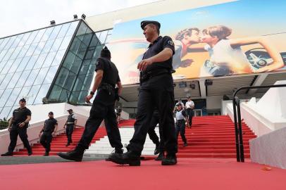 Policemen take part in preparation on the red carpet outside the Palais des Festivals in the southeastern French city of Cannes on May 07, 2018, on the eve of the opening of the 71st Cannes Film Festival.  / AFP PHOTO / Valery HACHE