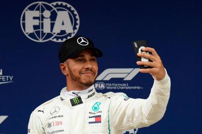 Mercedes British driver Lewis Hamilton takes a selfie after taking the pole position in the qualifying session at the Circuit de Catalunya in Montmelo in the outskirts of Barcelona on May 12, 2018 ahead of the Spanish Formula One Grand Prix. / AFP PHOTO / LLUIS GENE