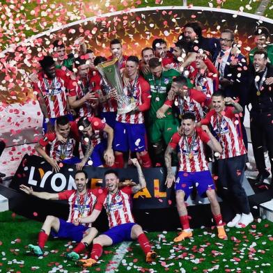 Atletico Madrids Spanish forward Fernando Torres (C) holds the trophy past teammates after winning the UEFA Europa League final football match between Olympique de Marseille and Club Atletico de Madrid at the Parc OL stadium in Decines-Charpieu, near Lyon on May 16, 2018.Atletico won 3-0. / AFP PHOTO / Jean-Philippe KSIAZEK