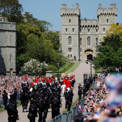 Britains Prince Harry, Duke of Sussex and his wife Meghan, Duchess of Sussex wave from the Ascot Landau Carriage during their carriage procession on the Long Walk as they head back towards Windsor Castle in Windsor, on May 19, 2018 after their wedding ceremony.  / AFP PHOTO / Tolga AKMEN