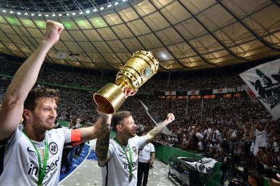 Frankfurts Argentinian defender David Abraham (L) and Frankfurts German defender Marco Russ celebrate with the trophy after the German Cup DFB Pokal final football match FC Bayern Munich vs Eintracht Frankfurt at the Olympic Stadium in Berlin on May 19, 2018.  / AFP PHOTO / Tobias SCHWARZ / RESTRICTIONS: ACCORDING TO DFB RULES IMAGE SEQUENCES TO SIMULATE VIDEO IS NOT ALLOWED DURING MATCH TIME. MOBILE (MMS) USE IS NOT ALLOWED DURING AND FOR FURTHER TWO HOURS AFTER THE MATCH. == RESTRICTED TO EDITORIAL USE == FOR MORE INFORMATION CONTACT DFB DIRECTLY AT +49 69 67880 / 