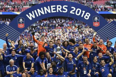 Chelsea players celebrate with the trophy after their victory in the English FA Cup final football match between Chelsea and Manchester United at Wembley stadium in London on May 19, 2018.Chelsea won the game 1-0. / AFP PHOTO / Glyn KIRK / NOT FOR MARKETING OR ADVERTISING USE / RESTRICTED TO EDITORIAL USE