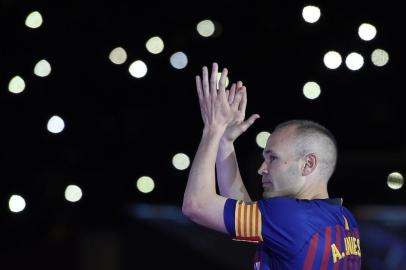 Barcelonas Spanish midfielder Andres Iniesta acknowledges fans during a tribute at the end of the Spanish league football match between FC Barcelona and Real Sociedad at the Camp Nou stadium in Barcelona on May 20, 2018.Iniesta, who joined Barcelonas academy 22 years ago, played his final game for the club. / AFP PHOTO / LLUIS GENE