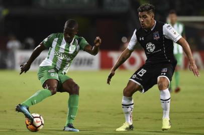 Colombias Atletico Nacional Helibelton Palacios (L) vies for the ball with Chiles Colo Colo Cesar Pinares during their Copa Libertadores football match at the Atanasio Girardot stadium, in Medellin, Antioquia department, Colombia on May 24, 2018.   / AFP PHOTO / JOAQUIN SARMIENTO