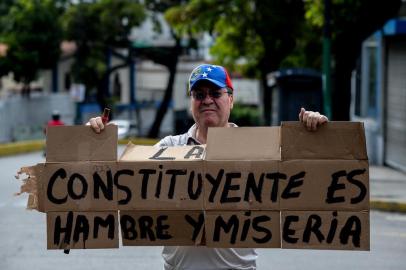  A man holds a cardboard reading The Constituent is Hunger and Misery in Caracas, during a 48-hour general strike called by the opposition, on July 26, 2017.Venezuelans began blocking off deserted streets Wednesday as the opposition launched a 48-hour general strike aimed at thwarting embattled President Nicolas Maduros controversial plans to rewrite the countrys constitution. / AFP PHOTO / Federico PARRAEditoria: POLLocal: CaracasIndexador: FEDERICO PARRASecao: strikeFonte: AFPFotógrafo: STF