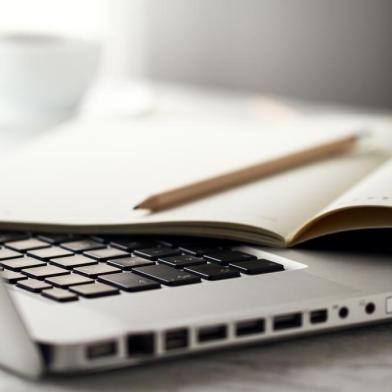 Closeup of Workspace with Modern Creative Laptop, Cup of Coffee and Pencils. Horizontal with Copy Space. 