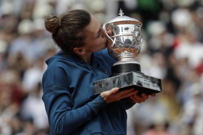 Romanias Simona Halep kisses her trophy, after winning the womens singles final match against Sloane Stephens of the US, on day fourteen of The Roland Garros 2018 French Open tennis tournament in Paris on June 9, 2018. / AFP PHOTO / Thomas SAMSON