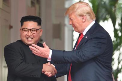  US President Donald Trump (R) shakes hands with North Korea's leader Kim Jong Un as they meet at the start of their historic US-North Korea summit, at the Capella Hotel on Sentosa island in Singapore on June 12, 2018.Donald Trump and Kim Jong Un have become on June 12 the first sitting US and North Korean leaders to meet, shake hands and negotiate to end a decades-old nuclear stand-off. / AFP PHOTO / SAUL LOEBEditoria: POLLocal: SingaporeIndexador: SAUL LOEBSecao: diplomacyFonte: AFPFotógrafo: STF