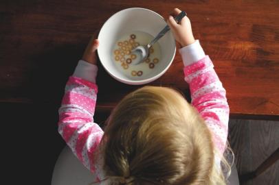 criança comendo leite com cereal