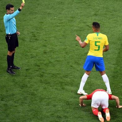 Referee Cesar Ramos (L) shows a yellow card to Brazils midfielder Casemiro during the Russia 2018 World Cup Group E football match between Brazil and Switzerland at the Rostov Arena in Rostov-On-Don on June 17, 2018. / AFP PHOTO / KHALED DESOUKI / RESTRICTED TO EDITORIAL USE - NO MOBILE PUSH ALERTS/DOWNLOADS