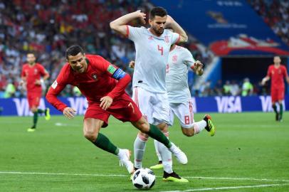 Portugals forward Cristiano Ronaldo falls down after being tackled by Spains defender Nacho Fernandez (R) during the Russia 2018 World Cup Group B football match between Portugal and Spain at the Fisht Stadium in Sochi on June 15, 2018. / AFP PHOTO / Nelson Almeida / RESTRICTED TO EDITORIAL USE - NO MOBILE PUSH ALERTS/DOWNLOADS