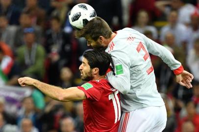  Spain's defender Gerard Pique (R) vies for the header with Iran's forward Karim Ansari Fard during the Russia 2018 World Cup Group B football match between Iran and Spain at the Kazan Arena in Kazan on June 20, 2018. / AFP PHOTO / SAEED KHAN / RESTRICTED TO EDITORIAL USE - NO MOBILE PUSH ALERTS/DOWNLOADSEditoria: SPOLocal: KazanIndexador: SAEED KHANSecao: soccerFonte: AFPFotógrafo: STF