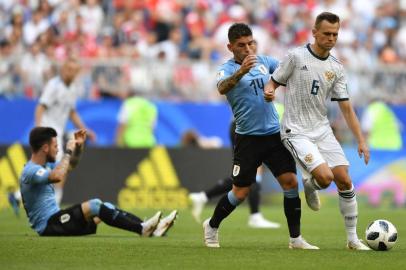  Russias midfielder Denis Cheryshev (R) challenges Uruguays midfielder Lucas Torreira during the Russia 2018 World Cup Group A football match between Uruguay and Russia at the Samara Arena in Samara on June 25, 2018. / AFP PHOTO / Fabrice COFFRINI / RESTRICTED TO EDITORIAL USE - NO MOBILE PUSH ALERTS/DOWNLOADSEditoria: SPOLocal: SamaraIndexador: FABRICE COFFRINISecao: soccerFonte: AFPFotógrafo: STF