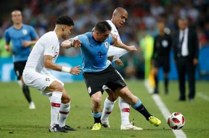 Uruguays midfielder Cristian Rodriguez (C) is marked by Portugals defender Pepe (L) during the Russia 2018 World Cup round of 16 football match between Uruguay and Portugal at the Fisht Stadium in Sochi on June 30, 2018. / AFP PHOTO /  / RESTRICTED TO EDITORIAL USE - NO MOBILE PUSH ALERTS/DOWNLOADS