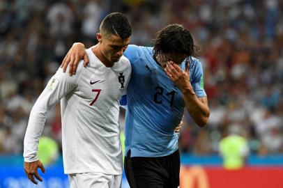 Uruguays forward Edinson Cavani (2ndL) leaves the pitch comforted by Portugals forward Cristiano Ronaldo during the Russia 2018 World Cup round of 16 football match between Uruguay and Portugal at the Fisht Stadium in Sochi on June 30, 2018. / AFP PHOTO / Jonathan NACKSTRAND / RESTRICTED TO EDITORIAL USE - NO MOBILE PUSH ALERTS/DOWNLOADS