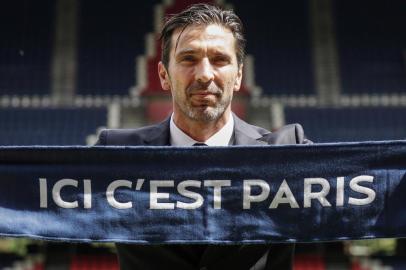 Italian goalkeeper Gianluigi Buffon poses with his new clubs scarf on July 9, 2018 at the Parc des Princes stadium in Paris, after French Ligue 1 football champions Paris Saint-Germain recruited him for a one-year deal. / AFP PHOTO / Thomas SAMSON