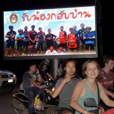 Motorists pass a billboard with a photograph showing members of the Thai children's football team "Wild Boar" and their coach with a message "welcome home brothers" displayed in Chiang Rai as the boys and their coach were all rescued in the Tham Luang cave in Khun Nam Nang Non Forest Park in the Mae Sai district on July 10, 2018.All 12 boys and their coach who became trapped in a flooded Thai cave more than a fortnight ago have been rescued, the Navy SEALs announced on July 10, completing an astonishing against-the-odds rescue mission that has captivated the world. / AFP PHOTO / TANG CHHIN Sothy