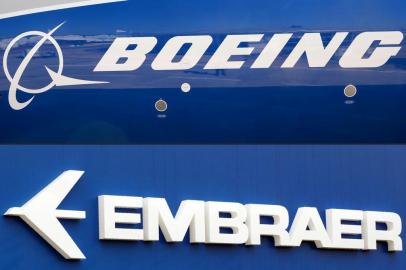 -(FILES) This file photo composition created on December 21, 2017  shows the Boeing logo on the fuselage of a Boeing 787-10 Dreamliner test plane presented on the tarmac of Le Bourget airport near Paris on June 18, 2017, and the logo of Brazils aircraft manufacturer Embraer also taken at Le Bourget airport, on June 23, 2013.On February 2, 2018 Embraer stocks rose almost 5% on the Sao Paulo Stock Exchange, following the leaking of a possible agreement between the Brazilian aircraft manufacturer and the US company Boeing for the joint development of commercial aircrafts. / AFP PHOTO / ERIC PIERMONTEditoria: FINLocal: Le BourgetIndexador: ERIC PIERMONTSecao: merger, acquisition and takeoverFonte: AFPFotógrafo: STF