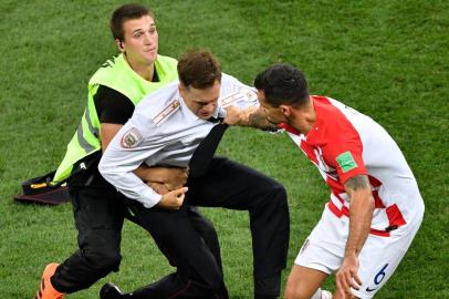  A striker is evacuated from the football pitch by security guards and Croatia's defender Dejan Lovren (R) during the Russia 2018 World Cup final football match between France and Croatia at the Luzhniki Stadium in Moscow on July 15, 2018. / AFP PHOTO / Alexander NEMENOV / RESTRICTED TO EDITORIAL USE - NO MOBILE PUSH ALERTS/DOWNLOADSEditoria: SPOLocal: MoscowIndexador: ALEXANDER NEMENOVSecao: soccerFonte: AFPFotógrafo: STF