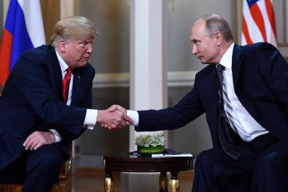 Russian President Vladimir Putin (R) and US President Donald Trump shake hands before a meeting in Helsinki, on July 16, 2018. / AFP PHOTO / Brendan Smialowski