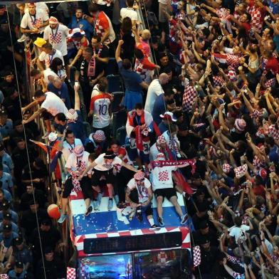 Croatian national football team players ride a bus as people gather for a heroes welcome in tribute to their national team, after reaching the final at the Russia 2018 World Cup, at the Bana Jelacica Square in Zagreb on July 16, 2018. / AFP PHOTO / Denis Lovrovic