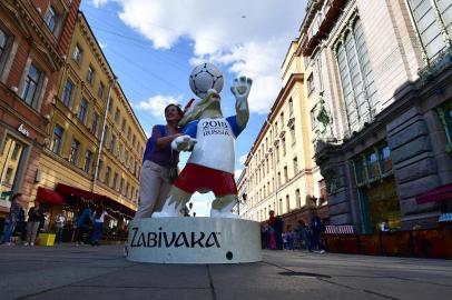  A woman poses next to Russia 2018 World Cup mascot "Zabivaka" in  Saint Petersburg on June 14, 2018. / AFP PHOTO / GIUSEPPE CACACEEditoria: SPOLocal: Saint PetersburgIndexador: GIUSEPPE CACACESecao: soccerFonte: AFPFotógrafo: STF