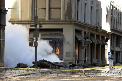 A worker looks at steam coming from 5th Avenue after a steam explosion tore apart the street in the Flatiron District of New York on July 19, 2018. Officials, according to media reports, said firefighters responded and were evacuating buildings near the accident. The Fire Department of the City of New York reported no injuries or deaths. TIMOTHY A. CLARY / AFP