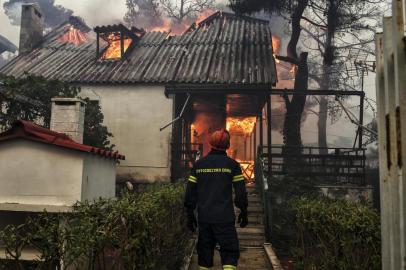  A firefighter stands in front of a burning house during a wildfire in Kineta, near Athens, on July 23, 2018. More than 300 firefighters, five aircraft and two helicopters have been mobilised to tackle the extremely difficult situation due to strong gusts of wind, Athens fire chief Achille Tzouvaras said.   / AFP PHOTO / VALERIE GACHEEditoria: DISLocal: KinetaIndexador: VALERIE GACHESecao: fireFonte: AFPFotógrafo: STR