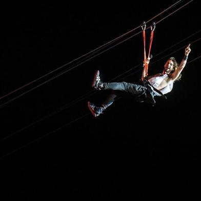 US singer Jared Leto, lead vocalist of 30 Seconds to Mars, performs on a zip-line during the Rock in Rio music festival in Rio de Janeiro, Brazil, on September 14, 2013. AFP PHOTO / YASUYOSHI CHIBA