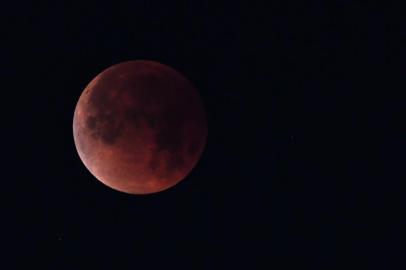 (FILES) In this file photo taken on January 31, 2018 the "super blue blood moon" is seen over Los Angeles, California.The longest "blood moon" eclipse this century will coincide with Mars' closest approach in 15 years to offer skygazers a thrilling astronomical double bill on Friday, astronomers say. For about half the world, the moon will be partly or fully in Earth's shadow from 1714 to 2328 GMT -- six hours and 14 minutes in all. / AFP PHOTO / Robyn Beck