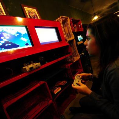  PORTO ALEGRE, RS, BRASIL 21H Crianças Adultas. Adultos que continuam brincando com jogos antigos. Na foto Fernanda Mambrini 22 anos (f. 92026486) joga no  Nintendo  o  game Super Mario Bros. (FOTO:JEAN SCHWARZ/ZERO HORA)