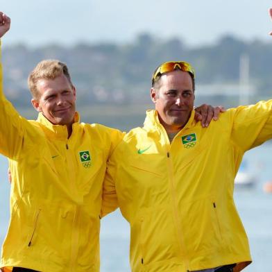 Bronze medalists Brazils Bruno Prada (L) and Robert Scheidt celebrate on the podium of the Star sailing class at the London 2012 Olympic Games, in Weymouth on August 5, 2012.  AFP PHOTO/William WEST