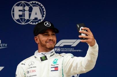 Mercedes British driver Lewis Hamilton takes a selfie after taking the pole position in the qualifying session at the Circuit de Catalunya in Montmelo in the outskirts of Barcelona on May 12, 2018 ahead of the Spanish Formula One Grand Prix. / AFP PHOTO / LLUIS GENE