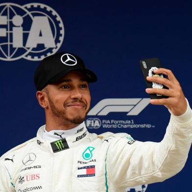 Mercedes British driver Lewis Hamilton takes a selfie after taking the pole position in the qualifying session at the Circuit de Catalunya in Montmelo in the outskirts of Barcelona on May 12, 2018 ahead of the Spanish Formula One Grand Prix. / AFP PHOTO / LLUIS GENE