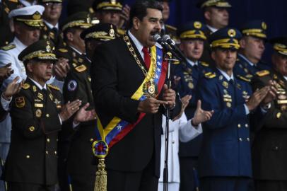 Venezuelan President Nicolas Maduro delivers a speech during a ceremony to celebrate the 81st anniversary of the National Guard in Caracas on August 4, 2018.Maduro was unharmed after an exploding drone attack, the minister of communication Jorge Rodriguez said following the incident, which saw uniformed military members break ranks and scatter after a loud bang interrupted the leaders remarks and caused him to look to the sky, according to images broadcast on state television. / AFP PHOTO / Juan BARRETO