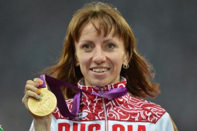 (FILES) - A picture taken on August 11, 2012 shows Russia's gold medalist Mariya Savinova celebrating on the podium of the women's 800m at the athletics event of the London 2012 Olympic Games. Russian athletes suspected of doping will be barred from competing at the world championships starting in Beijing next week, the All-Russian Athletics Federation said November 9, 2015.  On November 8, ARD reported that the International Association of Athletics Federations (IAAF) had recently demanded explanations from Russian sporting authorities regarding athletes suspected of doping, including Olympic gold medallist Mariya Savinova.  AFP PHOTO / JOHANNES EISELE