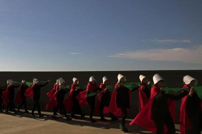 Activists in favour of the legalization of abortion disguised as characters from Canadian author Margaret Atwoods feminist dystopian novel The Handmaids Tale,  display green headscarves as they perform at the Parque de la Memoria (Remembrance Park) in Buenos Aires, on August 5, 2018. Argentinas Senate on August 1 approved the text of a bill to legalize abortion that will be put to a vote on August 8. As approved by Congress lower house on June 14, the bill sent to the Senate legalizes abortion during the first 14 weeks of pregnancy and provides for conscientious objection for practitioners, but not for a hospitals. / AFP PHOTO / ALEJANDRO PAGNI