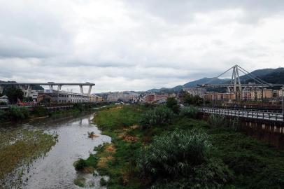 The Morandi motorway bridge is seen from a distance after a section collapsed earlier in Genoa on August 14, 2018. At least 30 people were killed on August 14 when the giant motorway bridge collapsed in Genoa in northwestern Italy. The collapse, which saw a vast stretch of the A10 freeway tumble on to railway lines in the northern port city, was the deadliest bridge failure in Italy for years, and the country's deputy transport minister warned the death toll could climb further. / AFP PHOTO / ANDREA LEONI