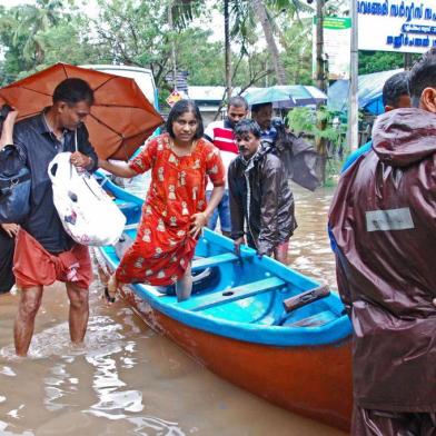  Indian volunteers and rescue personnel evacuate local residents in a boat in a residential area at Kozhikode, in the Indian state of Kerala, on August 16, 2018.The death toll from floods in India's tourist hotspot of Kerala increased to 77 on August 16, as torrential rainfall threatened new areas, officials told AFP. / AFP PHOTO / -Editoria: WEALocal: KozhikodeIndexador: -Secao: reportFonte: AFPFotógrafo: STR